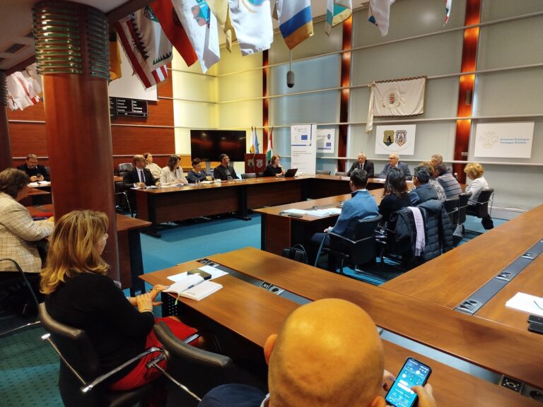 A Felzárkózási Fórum ülésének oldalnézeti képe, résztvevők jegyzetelnek és figyelemmel kísérik az elhangzottakat.